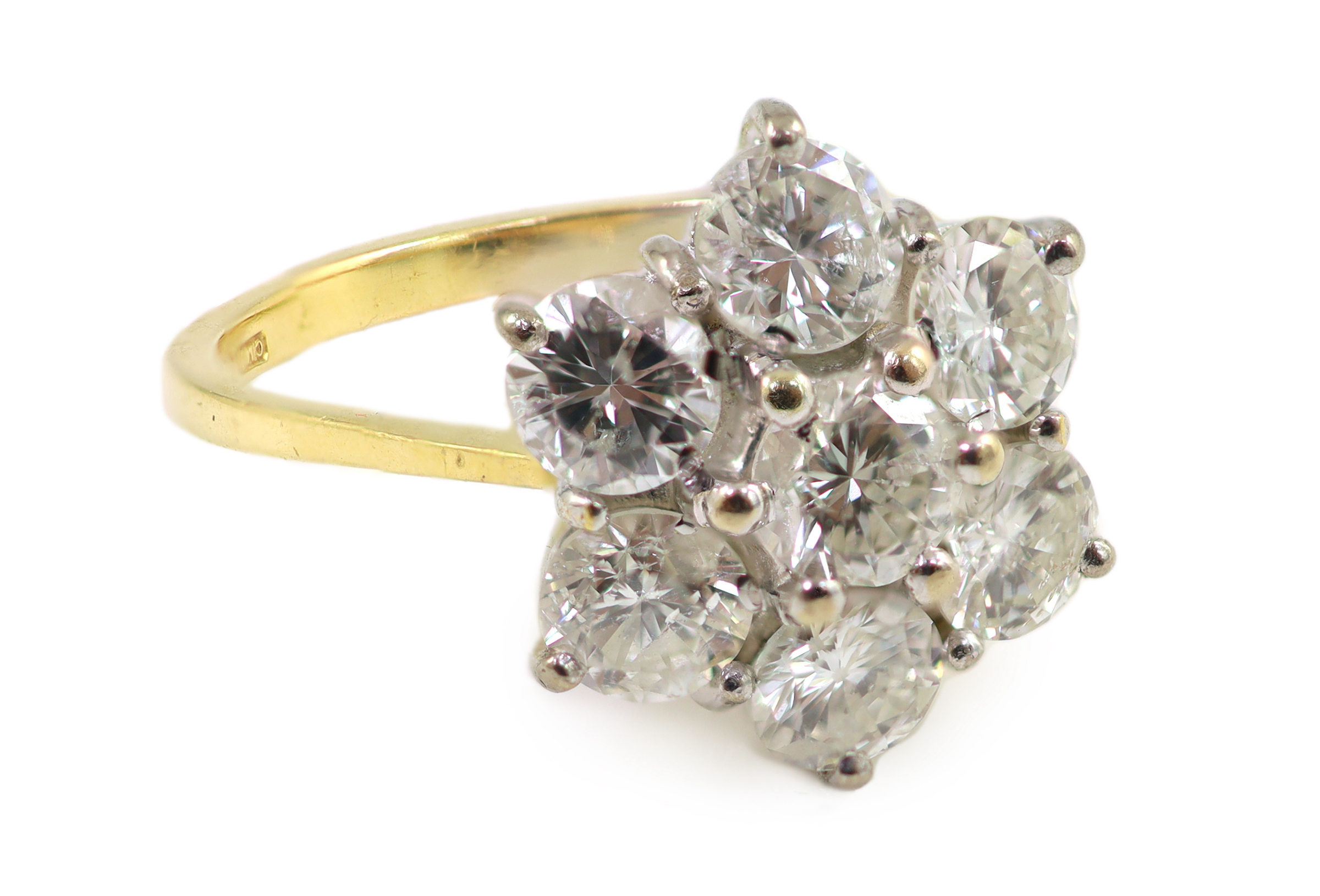 A modern 18ct gold and seven stone diamond set flower head cluster ring